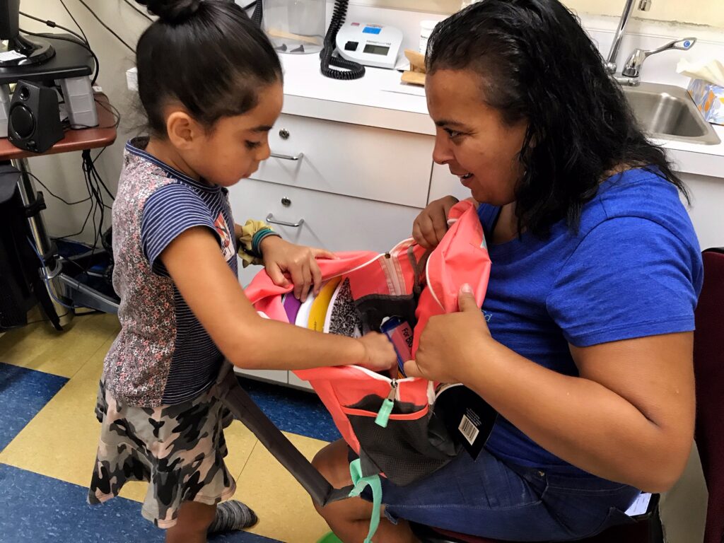 Child and Mom Opening New Backpack