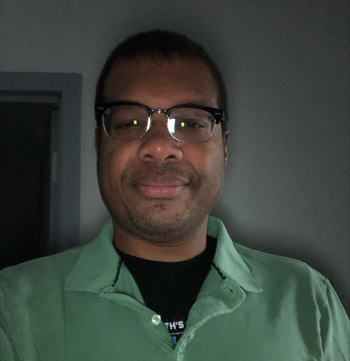 Headshot of Karim Walker in a green shirt